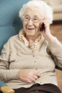 Senior Woman Talking On Mobile Phone Sitting In Chair
